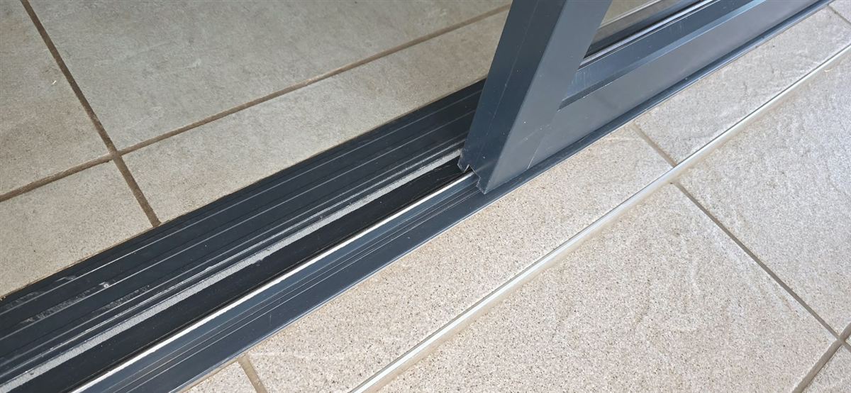 Close-up of aluminium sliding door frame and bottom running track